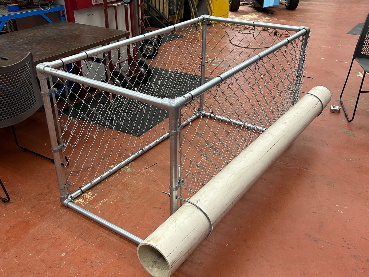 The frame wrapped in tensioned chain link fence with the first flotation pipe attached.