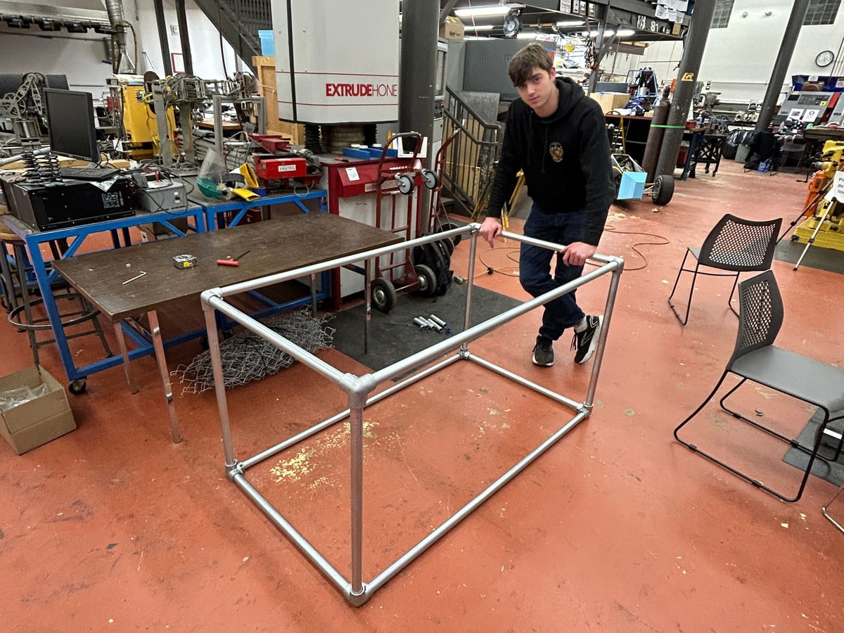 The bare metal pipe frame assembled with cast iron elbow connectors.