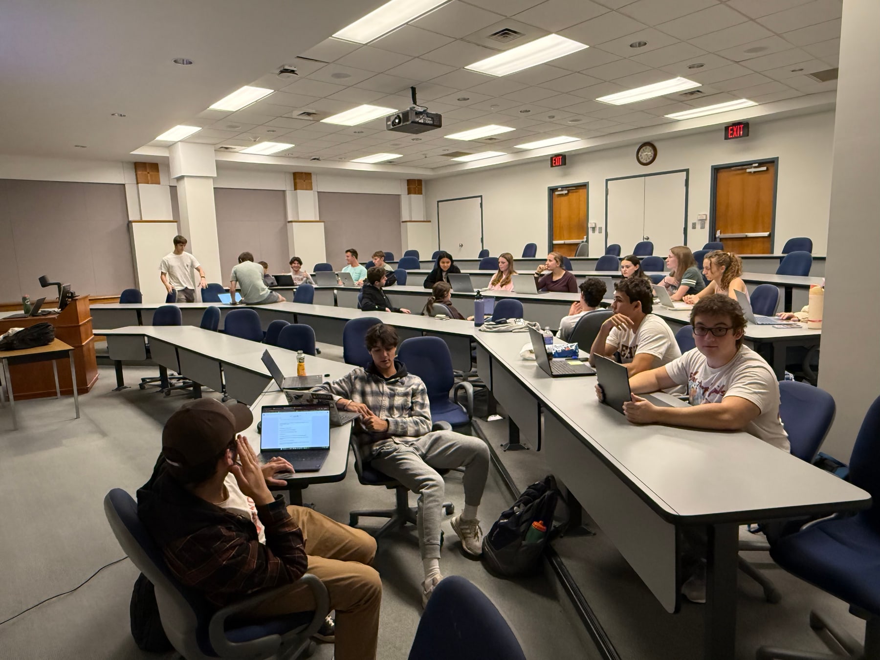 A lecture hall of members at a general body meeting, with a customer persona slide on screen.