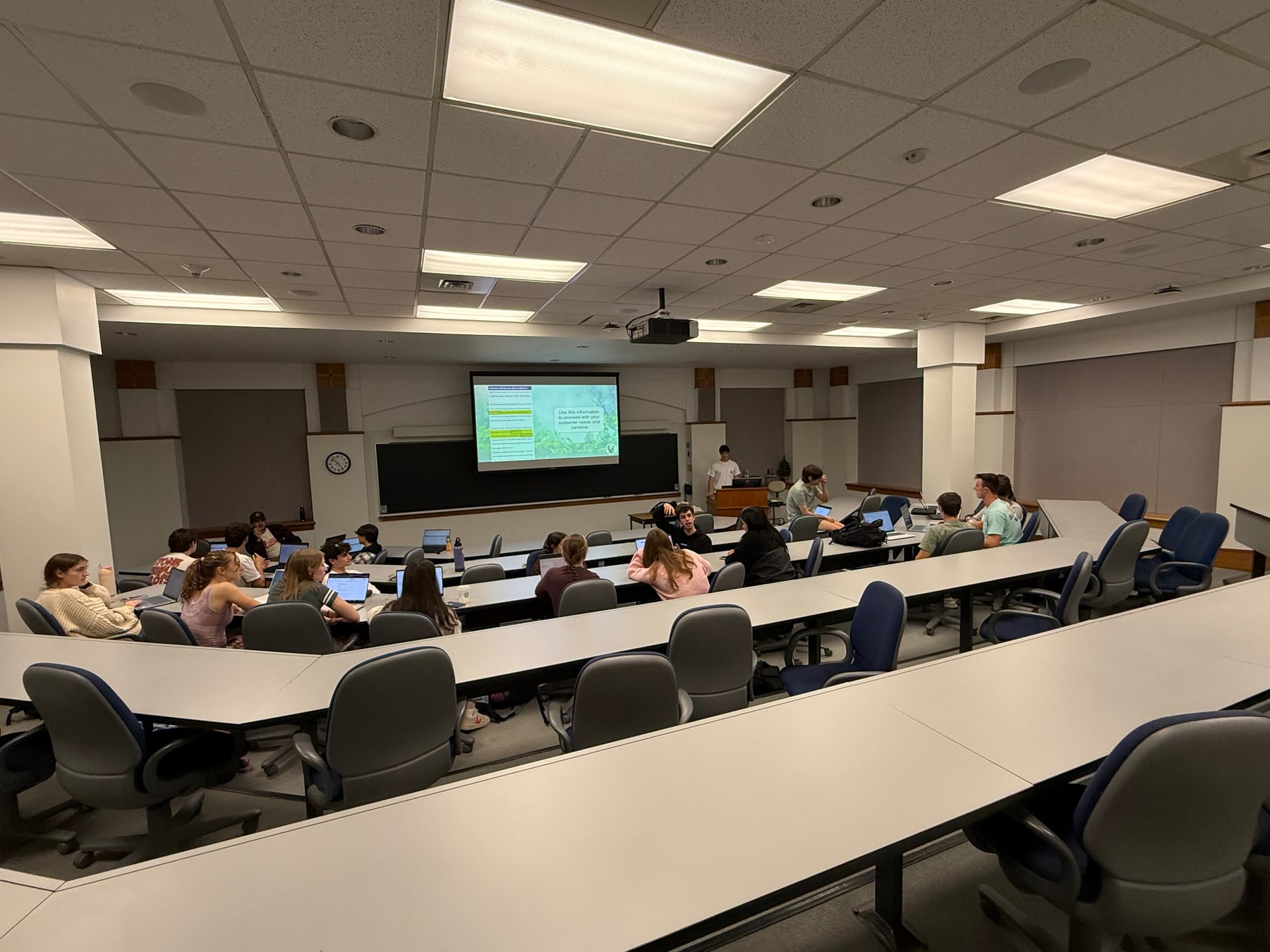A lecture hall of Sustainable Engineering Club members at a general body meeting, with a customer persona slide on screen.