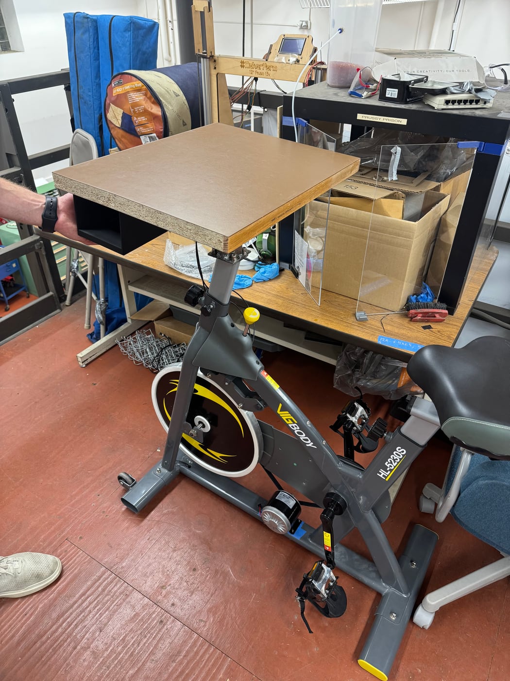 The exercise bike with a wooden desk surface mounted to it.