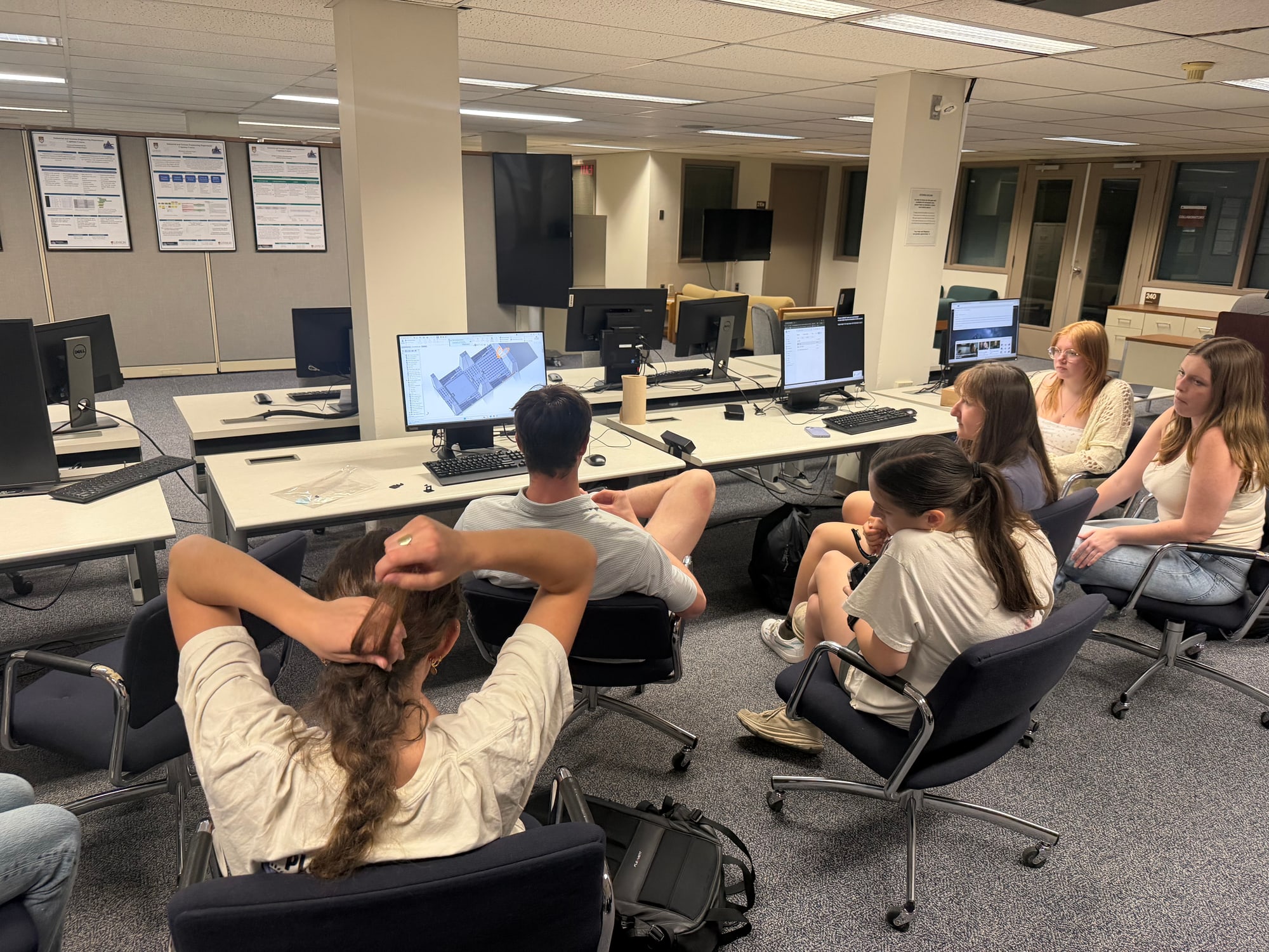 Club members gathered around a monitor showing the Urban Window Garden model in SolidWorks.