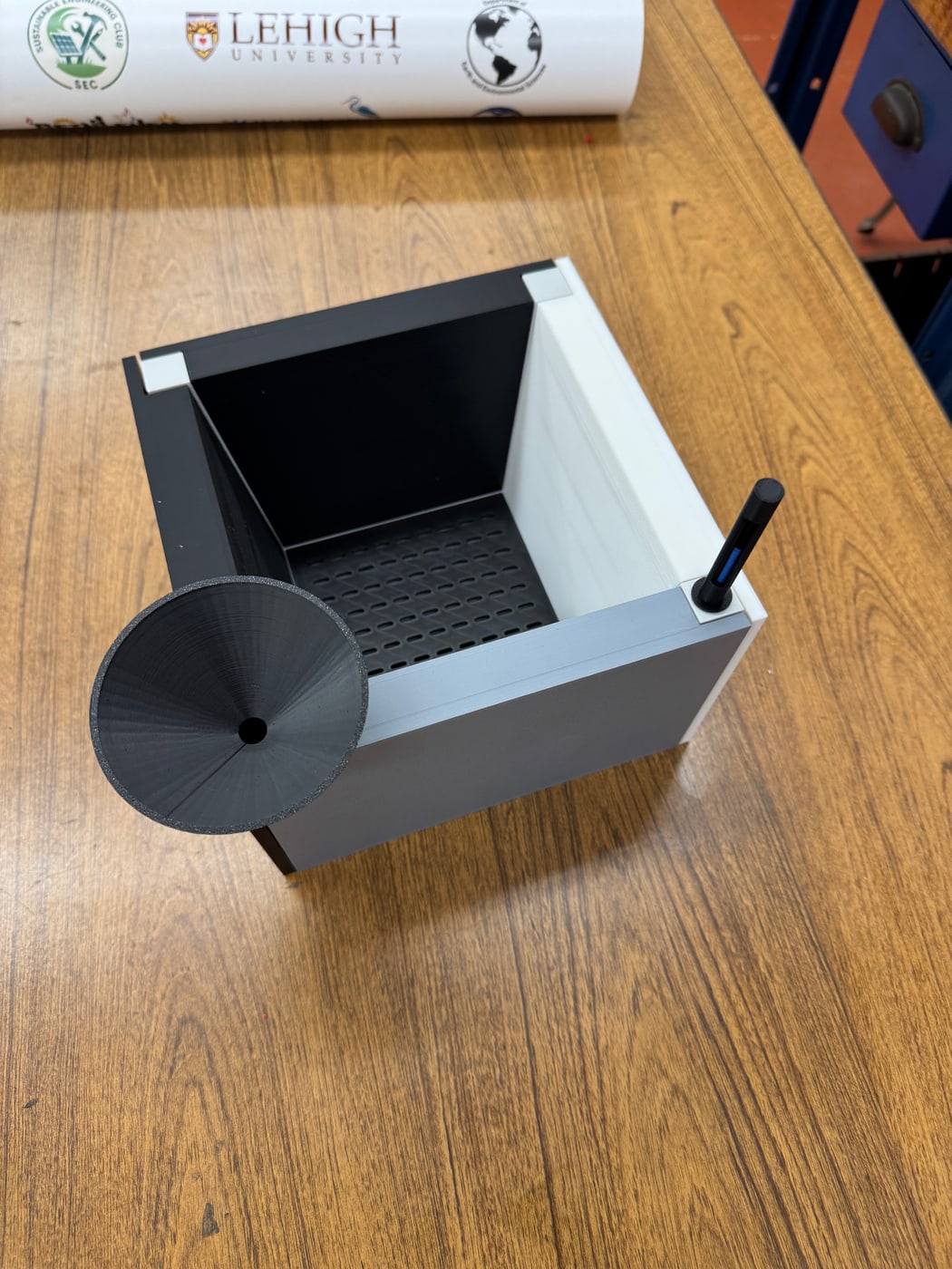 The 3D-printed Urban Window Garden prototype on a desk, with the funnel resting beside it.